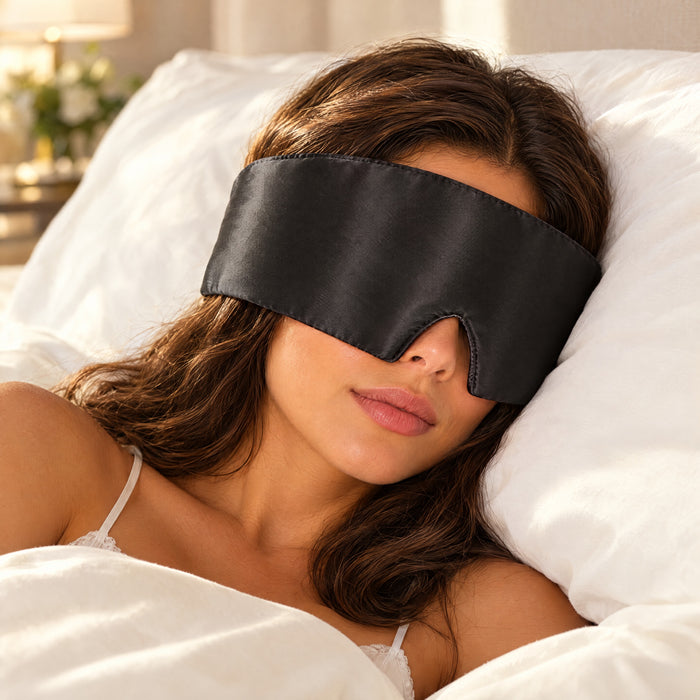 Vrouw slaapt op haar zij met een zwart zijden slaapmasker